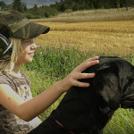 Flicka med labrador under jakt.